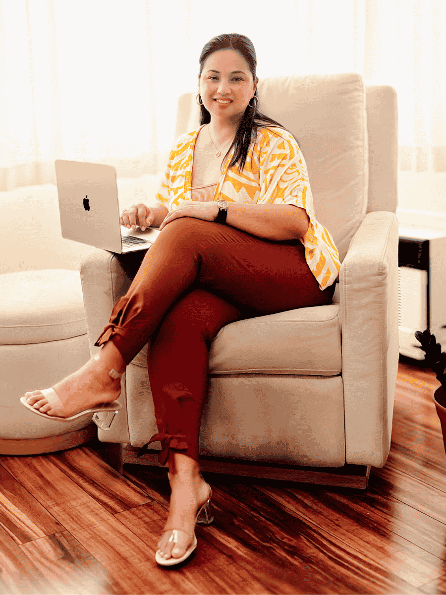 Diana Bejasa seated with a laptop, representing private leadership coaching for high-achieving leaders